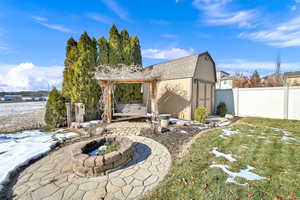 View of yard featuring a shed, a fire pit, and a patio