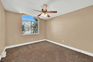 Bedroom with ceiling fan, carpet, and a textured ceiling