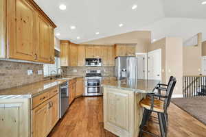 Kitchen with stainless steel appliances, a center island, sink, and granite countertops