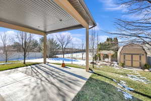 View of patio with a storage unit