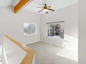 Carpeted spare room with beam ceiling and ceiling fan