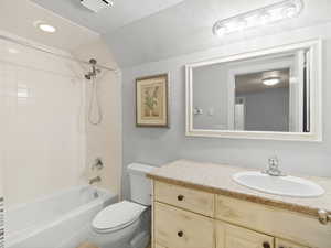 Full bathroom with vanity, toilet, and tiled shower / bath combo