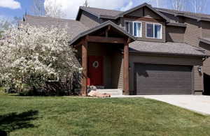 View of front of house with a garage and a front yard