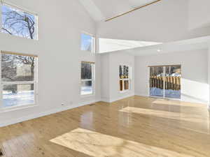 Spare room with a towering ceiling and light hardwood / wood-style flooring