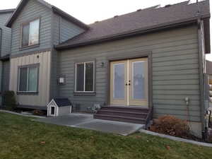 Rear view of house with a patio, a yard, and french doors