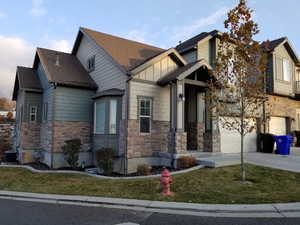 View of front of home with cooling unit and a garage