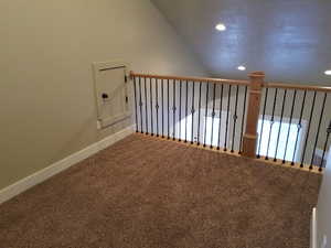 Interior space with carpet flooring and vaulted ceiling