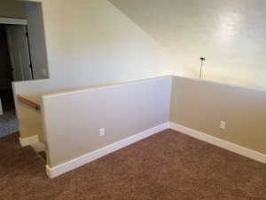 Carpeted spare room with lofted ceiling