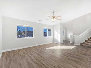 Unfurnished living room with wood-type flooring and ceiling fan