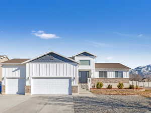 View of front of home with a mountain view and a garage