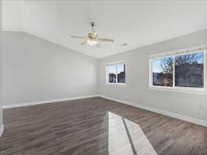 Unfurnished room with ceiling fan, lofted ceiling, and dark hardwood / wood-style floors