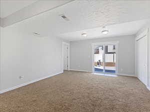 Spare room with carpet and a textured ceiling