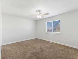 Carpeted spare room with ceiling fan