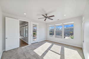 Unfurnished room featuring light carpet and ceiling fan