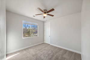 Unfurnished room featuring ceiling fan and carpet