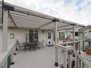 Deck with a pergola and a hot tub