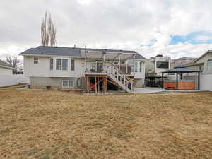 Rear view of property with a deck, a yard, a gazebo, a patio, and a hot tub