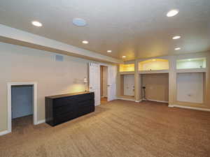 Basement featuring carpet flooring and a textured ceiling