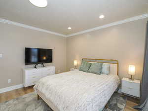 Bedroom featuring wood-type flooring and ornamental molding