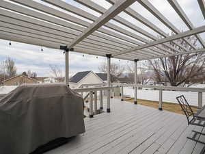 Wooden deck with area for grilling and a pergola