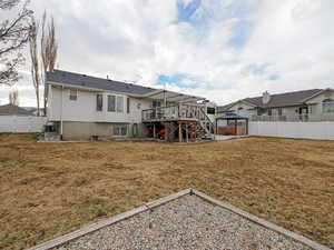 Rear view of house with a gazebo, a jacuzzi, a deck, and a lawn