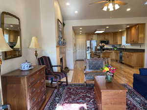 Living room with sink, ceiling fan, and light wood-type flooring