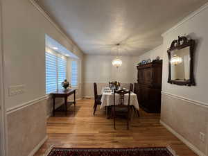 Dining space featuring ornamental molding, an inviting chandelier, and light wood-type flooring