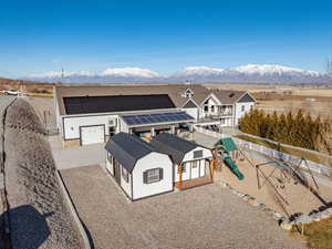 Exterior space with a garage, a playground, solar panels, and a mountain view