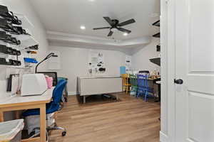 Office area with ceiling fan and light hardwood / wood-style flooring