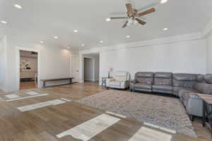 Living room with ceiling fan and light wood-type flooring