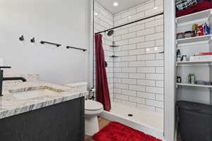 Bathroom with hardwood / wood-style floors, vanity, a shower with shower curtain, and toilet