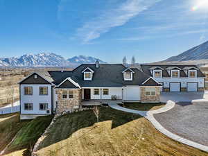 Rear view of property featuring a mountain view, a garage, and a lawn