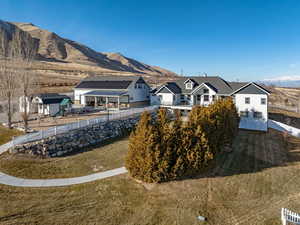 Back of property with a mountain view and a yard