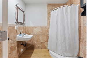 Bathroom featuring sink, tile walls, and walk in shower