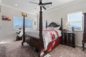 Carpeted bedroom featuring crown molding and ceiling fan