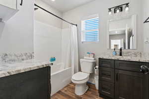 Full bathroom featuring vanity, wood-type flooring, toilet, and shower / bath combo with shower curtain