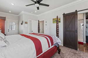 Bedroom featuring crown molding, a barn door, and ceiling fan