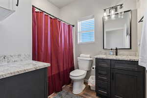 Bathroom featuring vanity, wood-type flooring, and toilet