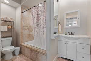 Full bathroom featuring shower / tub combo, vanity, tile patterned floors, and toilet