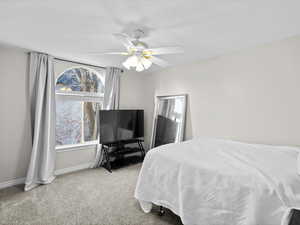 Bedroom with light colored carpet and ceiling fan