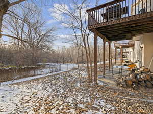 Yard layered in snow with a wooden deck