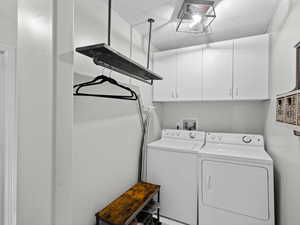 Laundry area featuring cabinets, independent washer and dryer, and a textured ceiling