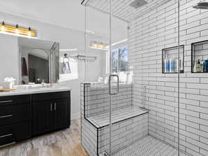 Bathroom featuring vanity, an enclosed shower, and hardwood / wood-style floors