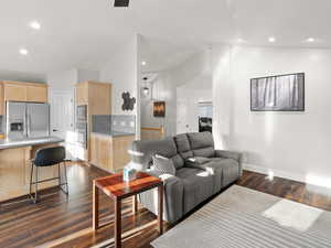 Living room with dark hardwood / wood-style floors and vaulted ceiling