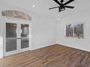 Empty room with french doors, ceiling fan, and wood-type flooring