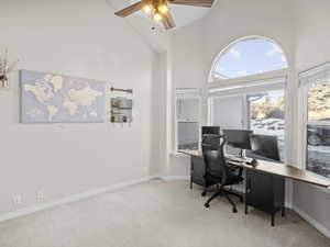 Office space featuring light carpet, high vaulted ceiling, and ceiling fan