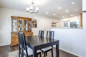 Dining space with dark hardwood / wood-style floors, sink, and a chandelier