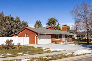 Single story home with a garage and a front lawn