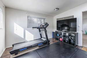 Exercise room featuring dark wood-type flooring and vaulted ceiling