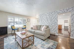 Living room with dark wood-type flooring and a textured ceiling